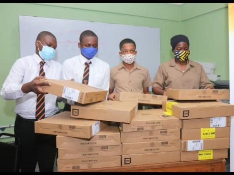 From left: Layandre’ Akoto, Damoyie Sterling, Tyreke Ellis and Jahlani Ustanny adjust the still-packaged Dell laptop computers that they were presented with during a handing-over ceremony at the school in Montego Bay on July 22, where 115 laptops were do