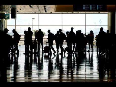 
In this March 17, 2021 photo, travellers walk through the Salt Lake City International Airport. 