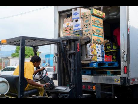 
A forklift operator loads goods on a truck at Everything Fresh Limited in Kingston.