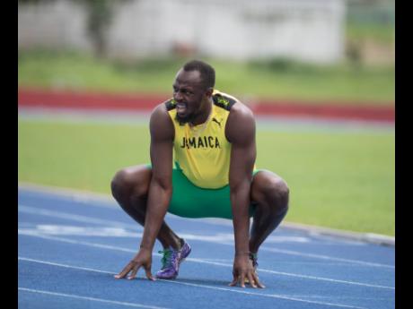 Olympic sprint great Usain Bolt catches his breath after competing in a Carmax promotional 800m race on July 13 at the University of the West Indies track named in his honour. The retired sprinter sputtered to a time of 2:39.