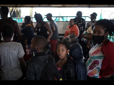 Migrants stand in line before boarding a boat that will take them to Capurgana, on the border with Panama, from Necocli, Colombia, Thursday, July 29. Migrants have been gathering in Necocli as they move north towards Panama on their way to the US border. 