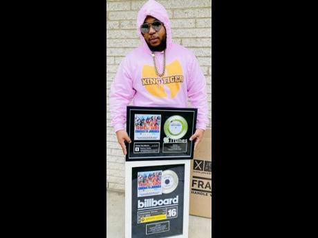 King Tiger shows off his Billboard plaques.