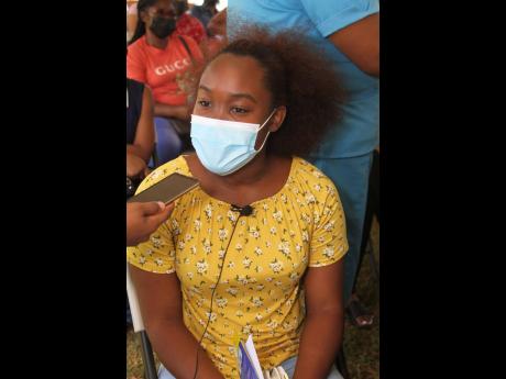 Eighteen-year-old Shaniellia Bramwell waiting to receive the first dose of the AstraZeneca vaccine yesterday at the Manchester High School in the parish.
