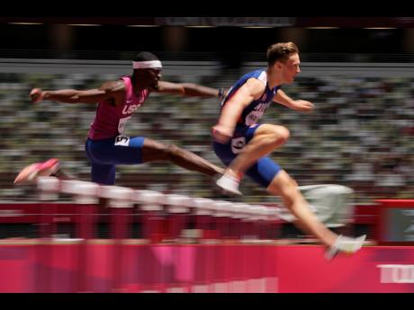 Karsten Warholm (right) of Norway, leads Rai Benjamin, of United States, on his way to a world record 45.94 seconds in the final of the Men's 400m hurdles at the 2020 Summer Olympics, in Tokyo, Japan on Tuesday.