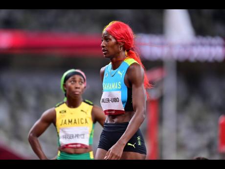 Jamaican sprinter Shelly-Ann Fraser-Pryce (left) looks for confirmation of her placing as The Bahamas’ Shaunae Miller-Uibo walks by following the women’s 200 metres final at the Tokyo 2020 Olympics, inside the Tokyo Olympic Stadium, Tokyo, Japan, yeste