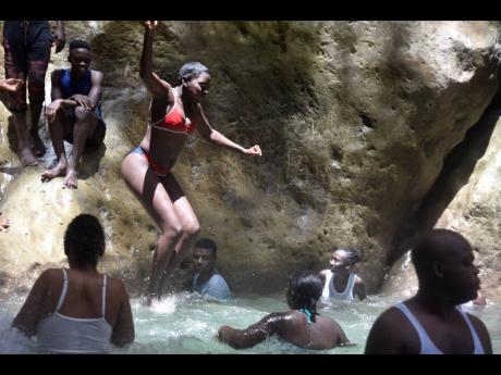 People having fun at the Cane River Falls in Nine Mile, Bull Bay, St Andrew on August 2.