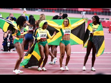 Members of Jamaica’s women’s 4x100 metres team celebrate after they won gold in a national record 41.02 seconds  at the Tokyo 2020 Olympics in Japan yesterday. From left:  Elaine Thompson-Herah, Shelly-Ann Fraser-Pryce, Briana Williams and Shericka Jac