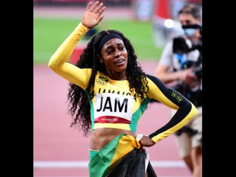 Elaine Thompson Herah waves to the crowd after Jamaica won gold in the women’s 4x100m at the Tokyo 2020 Olympics yesterday.