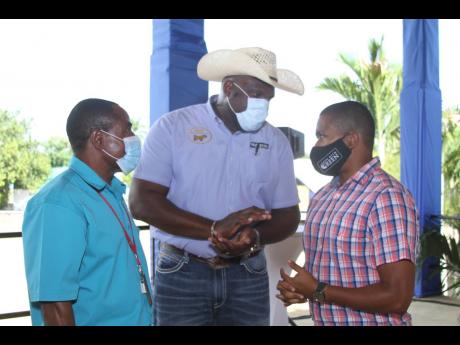 Agriculture Minister Floyd Green (right) in discussion with goat farmers at the GOAT seminar, held at the Denbigh Agricultural Showground in Clarendon on Wednesday, August 4.