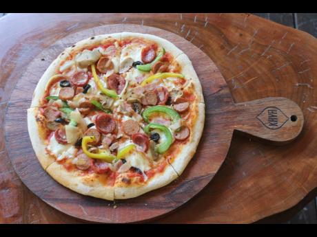 The Mystic, topped with meat and veggies gives all the feels of an artisan style pizza.