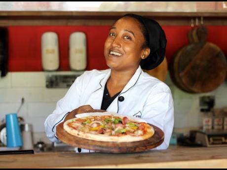 Chef Toni Yapp is all smiles as she hands over a speciality pizza. 
