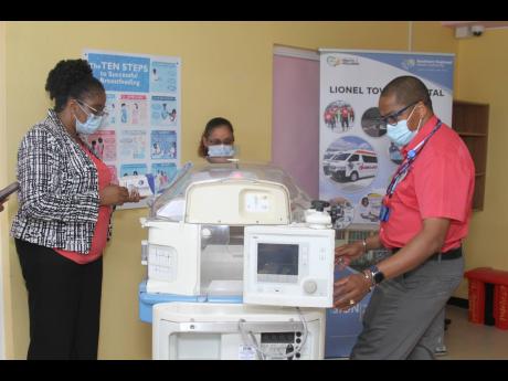 Dr Rodger Hunter (right), president Medical Strategies Associates Ltd, and consultant neurosurgeon and spinal surgeon explains the features of the incubator to Nadine Preddie, chief executive officer, Lionel Town Hospital and  Vasantie Dubrey, specialist n