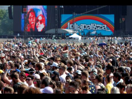 In this July 29, 2021 file photo, fans gather and cheer on day one of the Lollapalooza music festival at Grant Park in Chicago. Chicago health officials on Thursday reported 203 cases of COVID-19 connected to Lollapalooza, casting it as a number that was a