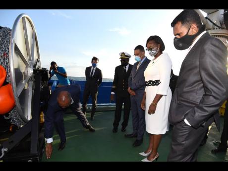 President and CEO of the Port Authority of Jamaica (PAJ) Professor Gordon Shirley (left) show Prime Minister Andrew Holness (third right) and his wife, Juliet Holness, along with Captain Hugh Helps (fourth right) and Alok Jain, chairman of the PAJ, a featu