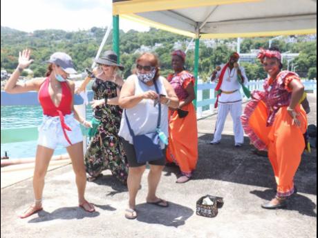 Some of the more than 3,000 passengers from the Carnival Sunrise cruise ship soak up the vibe from local entertainers at the Ocho Rios pier on Monday. 