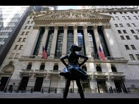 In this March 23, 2021 photo, the Fearless Girl statue stands in front of the New York Stock Exchange in New York’s financial district.