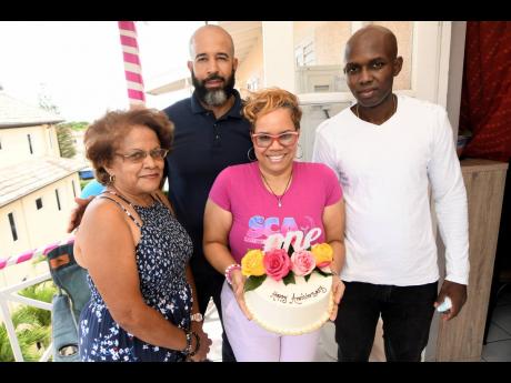 From left: Suwanee Caine shows off her cake made by Dawn Mitchell, while some members of her support system (from left) her mother, Pastor Carrington Morgan, and Carrington Hartley surround her with love.