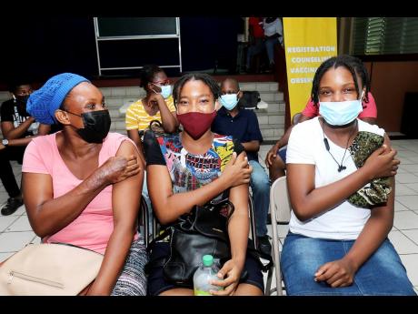 Photo by Ashley Anguin 
Vivia Kerr (left) and her daughters Nadia and Natania Kerr got their first COVID-19 shot during the vaccination blitz targeting children at Mount Alvernia High School in Montego Bay, St James on Saturday.