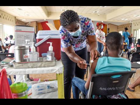 Nicholas Nunes/Photographer 
The youngsters are being inoculated with the Pfizer vaccine that arrived in Jamaica on Thursday, which were donated by the United States Government. Jamaica received 208,260 doses, which are part of a total allocation of over 6