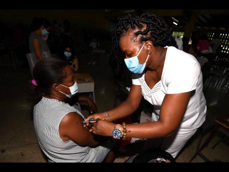 Nurse Simone Brown administers the Pfizer vaccinates to Claudett Hamilton during a vaccination blitz at Merl Grove High School on Saturday.