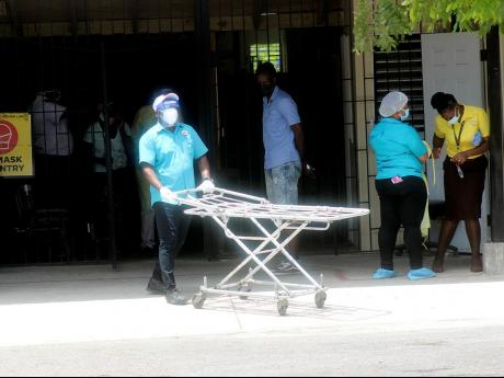 A porter pushes a gurney from the COVID-19 unit at the Cornwall Regional Hospital on Wednesday. Cornwall Regional and other hospitals were affected by an islandwide sickout.