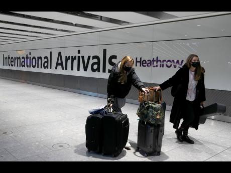 In this January 17, 2021 photo, travellers arrive at Heathrow Airport in London. Fuelled by a third wave of COVID-19, 'red list' designation for Jamaica could send tourism fortunes tanking again. 