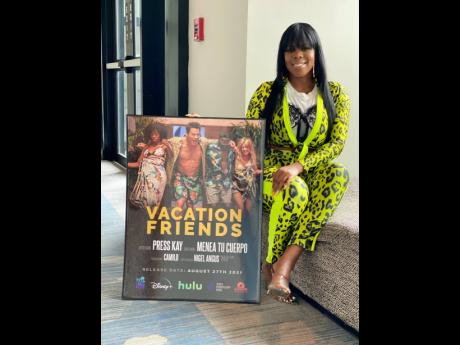 Press Kay poses with a plaque for ‘Vacation Friends’ from Hulu.