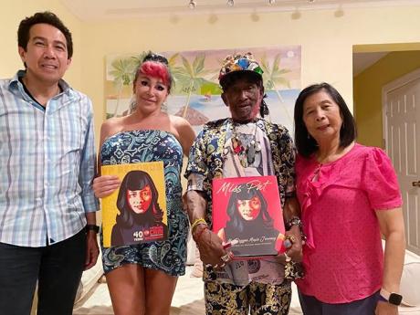 Lee ‘Scratch’ Perry and his wife Mareille hold copies of Patricia Chin’s book, ‘Miss Pat: My Reggae Journey’, which she presented to them when she visited the couple at their home in Negril in July. At left is VP Records CEO Chris Chin.