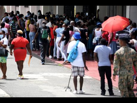A crowd swarms the National Arena vaccination site in Kingston on Monday. 
