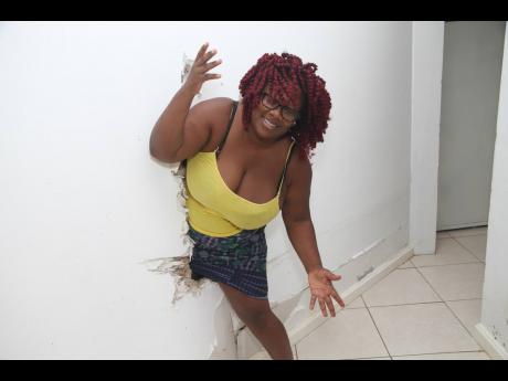 Christal Campbell demonstrates how she squeezed through a hole in the wall her partner Greg Nesbeth made for the family to escape to higher ground due to flooding in their home associated with Tropical Storm Ida. 
Several callsl reportedly made to the Four