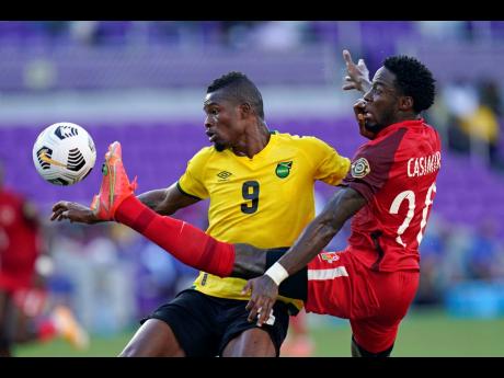 Guadeloupe defender Stevenson Casimir tries to clear the ball before Jamaica forward Cory Burke (left) can get in position for a shot on goal during the first half of their Concacaf Gold Cup Group C match, in Orlando, Florida, on Friday, July 16.