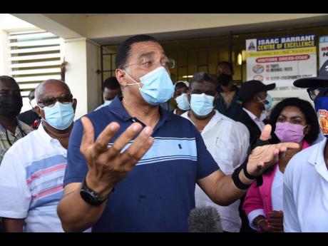 Prime Minister Andrew Holness addressing members of the media during a tour of the Isaac Barrant Health Centre in Hampton Court, St Thomas, on Wednesday.