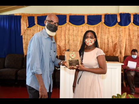 Granville Knight, a member of the Kitson Town Primary School Past Students’ Association, presents Clovia Facey with the Outstanding Achievement Award for being one of the top-performing PEP students from Kitson Town Primary School.
