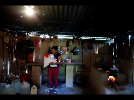 Dora Elena Ramirez holds her baby at her home in Las Tapias, San Marcos de Colón, in the department of Choluteca, Tegucigalpa, Honduras, on July 30. Residents here say more jobs would be welcome by the construction of semi-autonomous economic development 