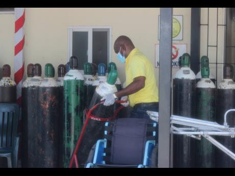 File 
A hospital worker moves an oxygen cylinder that was among several delivered to Cornwall Regional Hospital in Montego Bay on August 30. 