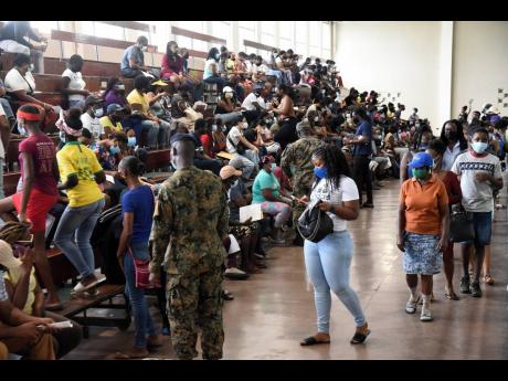 
Jamaica Defence Force soldiers direct visitors to available seating at the National Arena. Jamaica now has the ability to vaccinate persons from age 12 years and older and we must move with alacrity to ensure that all who are eligible and willing are vacc