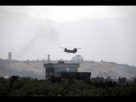 
In this Sunday, August 15, 2021 file photo, a US Chinook helicopter flies over the US embassy in Kabul, Afghanistan. Helicopters landed at the embassy as diplomatic vehicles left the compound amid the Taliban advance on the Afghan capital.