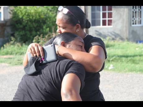 Family members mourn the death of Michael Solomon, who was among four persons killed in Havannahh Heights, Clarendon, just after midnight Saturday. The slaying of Solomon and his partner Sherona Whyte has made an orphan of their eight-year-old.