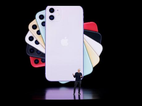 An image of iPhones form a backdrop for Apple CEO Tim Cook during a product announcement event on September 10, 2019, in Cupertino, California.