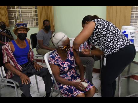 Camelia De’Ann Thompson, registered nurse, administers the one-shot Johnson & Johnson vaccine to Rita Brown at Mona Ageing and Wellness Centre on August 25.