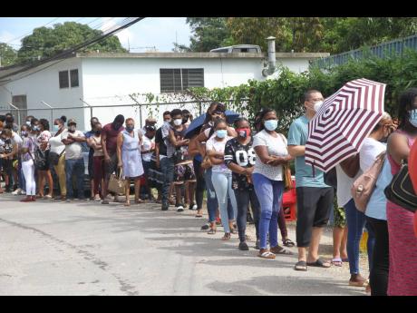 Scores of persons queue up for the vaccination blitz at Denbigh Primary School in May Pen, Clarendon, on Sunday, resulting in long lines extending beyond the gate. Dispensation of the Pfizer vaccine has been discontinued because stock is running out. More 