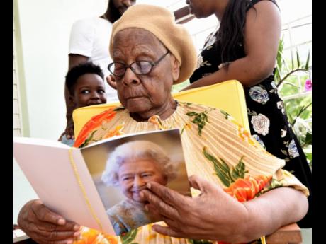 Centenarian Mavis Little reads a message sent to her by Queen Elizabeth.