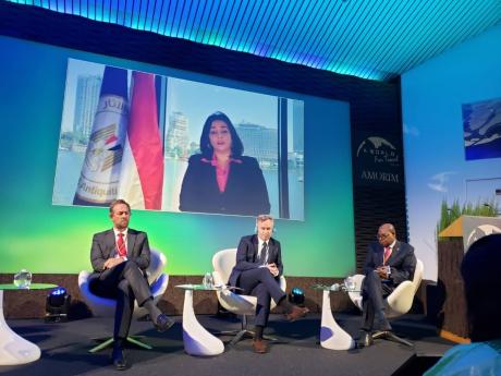 Tourism Minister Edmund Bartlett (right), listens attentively to the points raised by Ghada Shalaby, vice minister, tourism and antiquities, Arab Republic of Egypt (on screen) during a panel discussion at the highly anticipated ‘A World for Travel – É