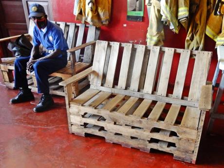A firefighter at the Ocho Rios fire station sit on one of several benches that firefighters at the station made, in the absence of sufficient seating at the fire station. Local Government Minister Desmond McKenzie has instructed that new chairs be ordered 