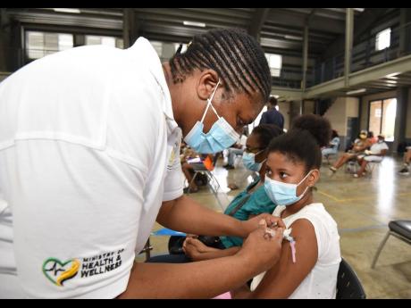Public health nurse Pauline Simpson administers a dose of Pfizer to Lee-Anne Oakley during a vaccination blitz held at Jamaica College on Monday, August 23. Children aged 12 and over are eligible for the COVID-19 vaccine. 