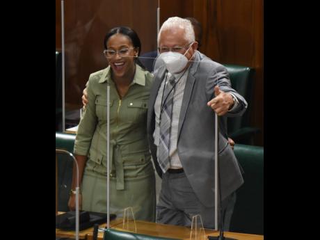 Rhoda Crawford (left), member of parliament for Manchester Central, gets a congratulatory hug from Delroy Chuck (right), member of parliament for St Andrew North East, shortly after she made her debut presentation to the state of the constituency debate in