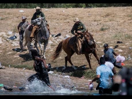 US Customs and Border Protection mounted officers attempt to contain migrants as they cross the Rio Grande from Ciudad Acuña, Mexico, into Del Rio, Texas, on Sunday. 