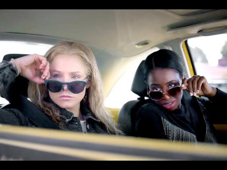 Kristen Bell (left) and Kirby Howell-Baptiste in a scene from ‘Queenpins’. 