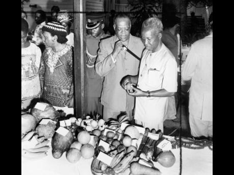 Jamaican fruits are examined by the Tanzanian President Julius K. Nyerere at Devon House when he attended a luncheon of Jamaican dishes. Telling him about the naseberry and other fruits is the Minister of Education Howard Cooke. 