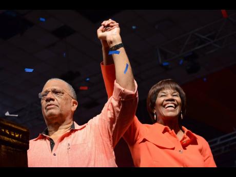 
Dr Peter Phillips the new President of the PNP holding the hands of the outgoing president Portia Simpson Miller at the People National Party special delegates conference at the National Arena on Sunday, March 26, 2017
